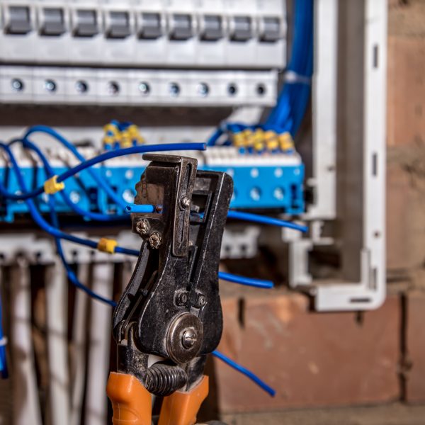 the Assembly of the electrical panel, electrician job, a robot with wires and circuit breakers, tools